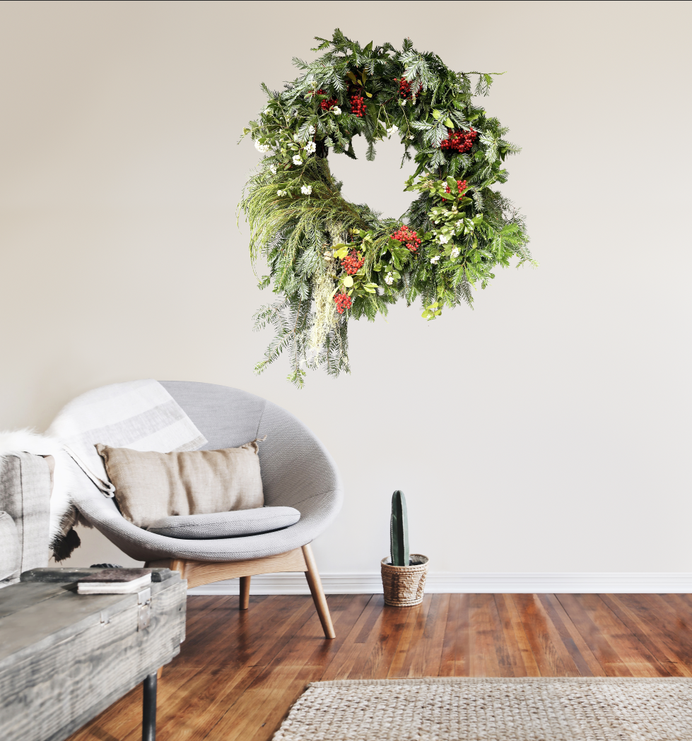 Decorative wreath hanging on a wall above a modern chair in a living room.